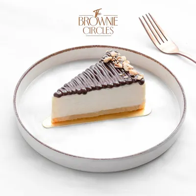 Our baked Hazelnut Cheesecake is a nutty delight. A creamy cheesecake base is infused with hazelnut flavor, topped with a chocolate drizzle and crunchy roasted hazelnuts.