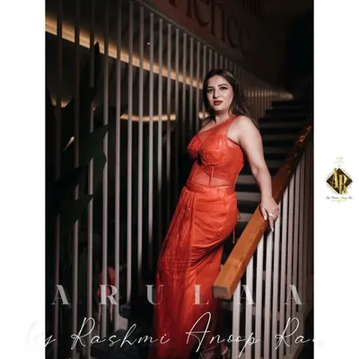 For actress Kaavya Sha, I designed this fiery red-orange fusion outfit. It features a corset-style boned top and a pre-draped skirt made of sequined fabric, creating a look that is both structured and glamorous.
