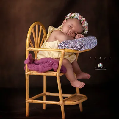 This wider view shows the full setup for this sweet portrait. The miniature high chair prop creates an adorable, slightly humorous scene of a sleeping baby, showcasing a more playful side of newborn photography.