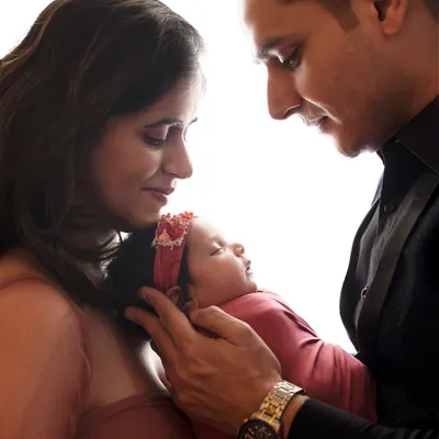 The world seems to stop in these quiet moments. A father and mother gazing at their newborn, a perfect circle of love. These are the memories that become family treasures.