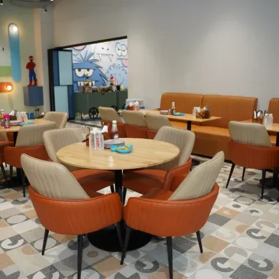 A view of our spacious and modern cafe, with comfortable booth seating and round tables. It's the perfect spot for parents to relax.