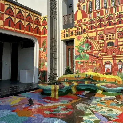 We transformed this entire residential courtyard in Rajkot into a labyrinth of color. The art begins with a hand-laid mosaic on the floor, rises up to form sculptural seating, and continues onto a large-scale architectural mural.