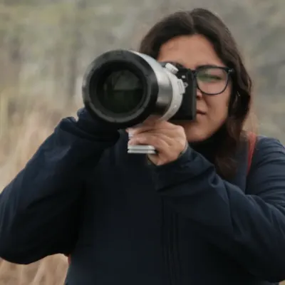 A portrait of me looking through the viewfinder of my camera, equipped with a large telephoto lens. This is my focused, in-the-zone look when I'm shooting wildlife.