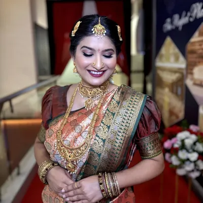 A radiant South Indian bride with a classic makeup look. We used warm gold tones on the eyes and a deep maroon lip to complement her silk saree and temple jewelry.