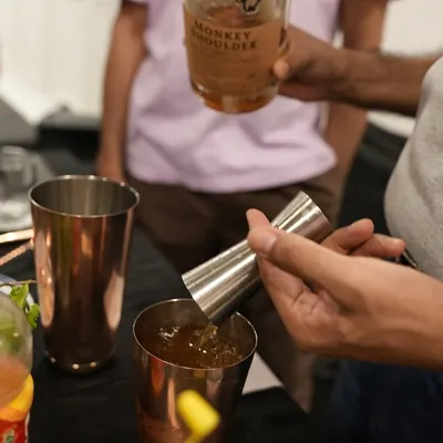 It all starts with quality ingredients. Here, we're measuring out Monkey Shoulder whisky with a jigger, a key tool for ensuring every cocktail is perfectly balanced. We teach you the importance of precise measurements for a consistent, delicious drink every time.