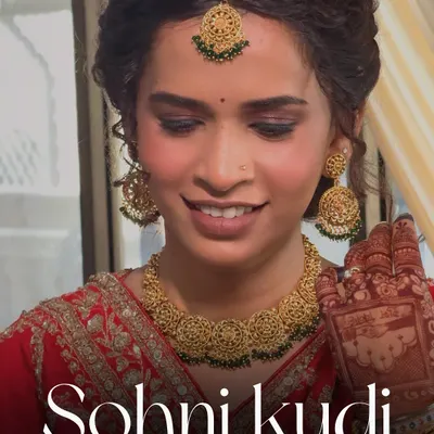 A beautiful 'Sohni Kudi' on her wedding day. This Punjabi bridal look features soft, smoky eyes and a radiant glow that perfectly complements her red attire and golden jewelry.