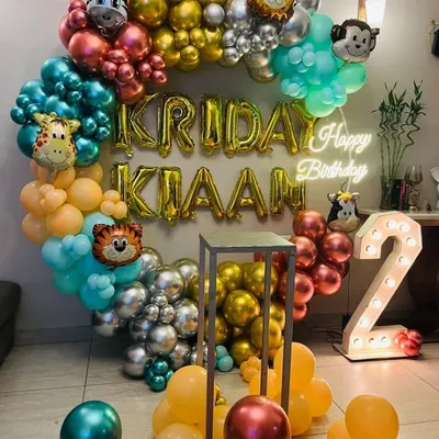A vibrant jungle safari theme for a 2nd birthday. This circular balloon arch is filled with colorful chrome balloons and various animal head foils like a tiger, giraffe, and zebra.