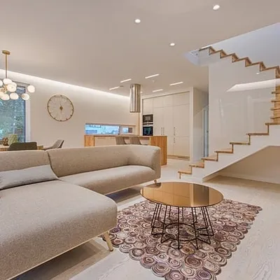 A bright, open-plan living space with clean white walls and a painted staircase. I handle complex interior projects that require a consistent, high-quality finish across multiple areas.