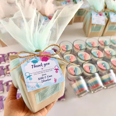 A beautiful baby shower return gift box I created for Nidhi and her family. It features a layered votive candle with tiny pink and blue baby feet and a purple baby onesie wax sachet, all perfectly packed and ready to delight guests.