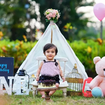 A perfect first birthday setup in the park, combining a cake smash, a teepee tent, and a friendly teddy bear. This outdoor session captures the joy of turning one in a natural, vibrant setting.