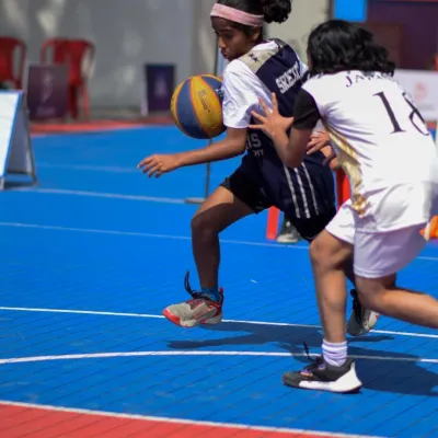A young athlete drives past her defender in a display of skill and determination. I create an environment where girls can compete fiercely and develop their basketball abilities in the Junior Basketball League.