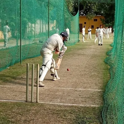 A batsman perfects his defensive stroke during a net session. Our coaches focus on mastering the fundamentals, ensuring every player has a solid and reliable technique.