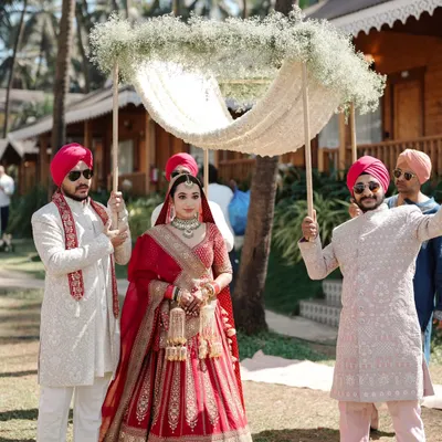 The grand bridal entry. We capture the bride's walk towards the mandap under a beautiful 'phoolon ki chadar' held by her brothers.