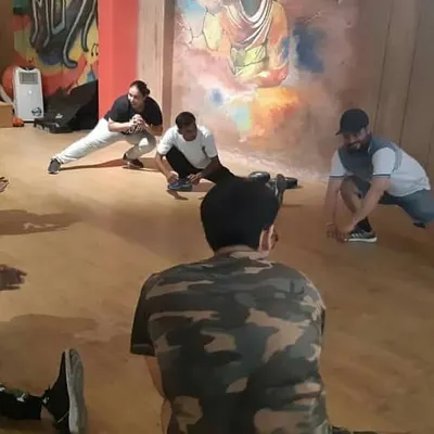 A group cool-down session at our garage fitness camp. Here, participants engage in deep stretches like side lunges to improve hip mobility and prevent muscle soreness after an intense workout.