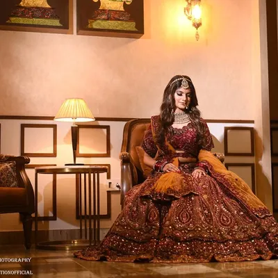 This portrait captures a model in a stunning bridal lehenga, but the room itself is a key part of the composition. The elegant armchair, the warm table lamp, and the classic wall details create a sophisticated atmosphere, perfect for high-end fashion and bridal photography.