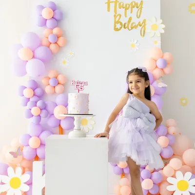 Turning five is a big deal. This portrait captures the birthday girl standing proudly next to her cake in a beautiful pastel flower-themed setup we designed together.