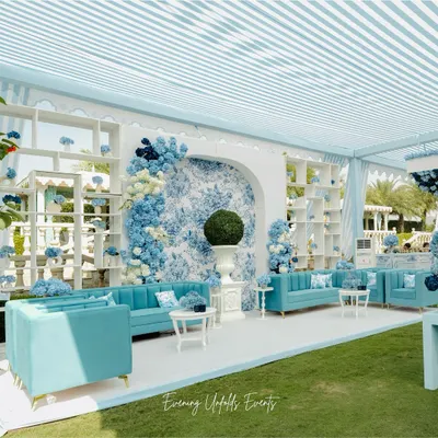 For this Dior-inspired Mehendi, we created a stunning lounge area featuring a custom floral-print backdrop and elegant blue sofas. The floral arrangements, with cascading blue and white hydrangeas, seamlessly integrate with the high-fashion theme.