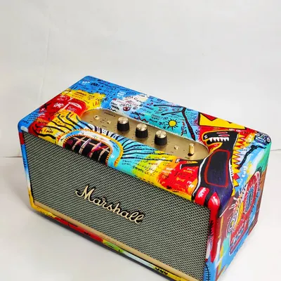 A full view of the custom-painted Marshall speaker. I covered the entire surface with a vibrant, freehand mashup of elements inspired by the artist Basquiat, turning a functional object into a statement art piece.