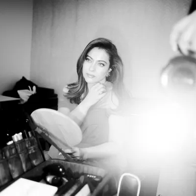 A behind the scenes black and white photo of Kajol getting ready for the 'Do Patti' trailer launch, looking stunning in a custom red gown.
