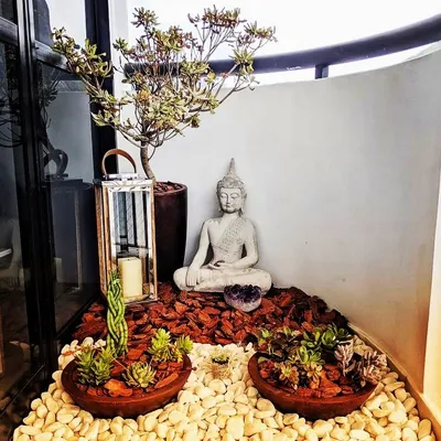 This is a classic zen corner I designed for a client. It features a meditating Buddha statue, a collection of low-maintenance succulents, and a mix of white pebbles and bark chips for texture, creating a calm and earthy display.