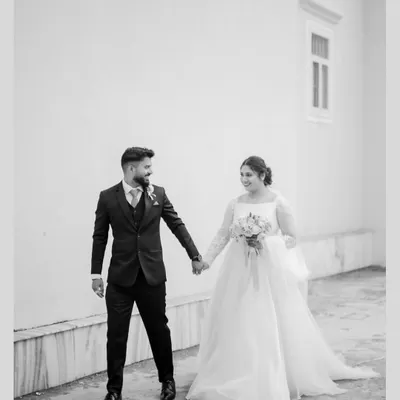 A classic black and white photograph of the bride and groom walking hand-in-hand after their church ceremony. This timeless style emphasizes emotion and connection.