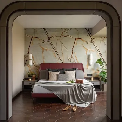 I designed this master retreat as a realm of understated elegance. Passing through the archway, you are greeted by a sanctuary of muted hues and natural textures, where a maroon bed against a cool marble wall invites blissful slumber.
