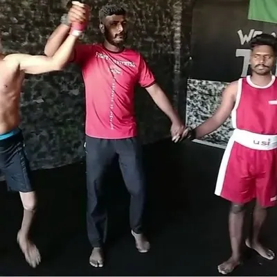 A moment of sportsmanship and victory after a tough bout. Our student T D Ramalingam, who overcame a physical disability, celebrates with his coach and opponent, embodying the respect and dedication we instill in our fighters.