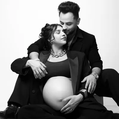 A modern and chic maternity portrait. The choice of matching black blazers creates a powerful, stylish look, while the black and white photography adds a timeless, intimate feel to the moment.