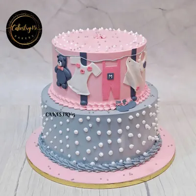 A charming 5kg pineapple cake for a baby shower. This two-tier design features a pink and grey color scheme with a cute clothesline decoration, teddy bear, and polka dots.