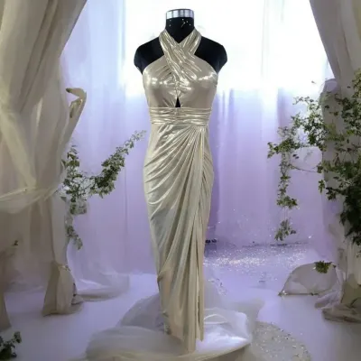 Step into the spotlight with this exquisite halter-neck gown. I designed this piece to make you dazzle at every party and special occasion, with its shimmering fabric and elegant draping.