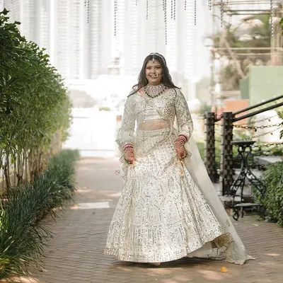 A breathtaking shot of our bride in her custom ivory lehenga. The full-body view shows the flow of the skirt and the perfection of the fit, designed for her wedding day.