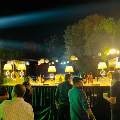 A wide shot of a large outdoor corporate event at night. I handled the entire setup, including the long, well-lit bar, ambient lighting, and overall event layout.