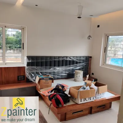 A bedroom during the painting process. As you can see, the bed and headboard are carefully wrapped in plastic to protect them from any dust or paint splatters.