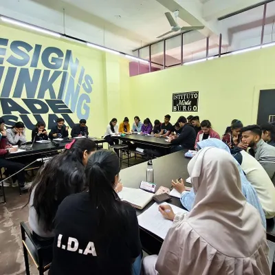 A full view of a workshop in session, with the "Design is Thinking Made Visual" motto on the wall. This captures the energy of our collaborative learning environment at Istituto Moda di Burgo.