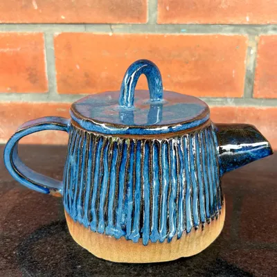 A beautiful hand-built teapot with carved vertical lines and a rich blue glaze. This piece was made by a student in my 15-day hand-building course.