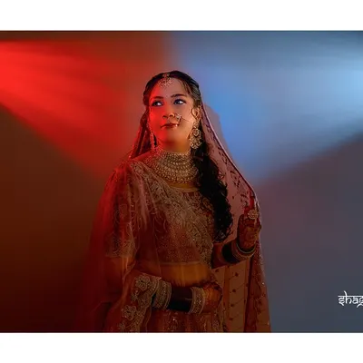 A creative bridal portrait using red and blue lights to create a dramatic and modern look. She stands as the perfect balance between passion and serenity.