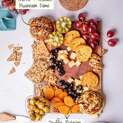 A top-down view of our classic cheese platter, showcasing two of our signature cheese domes: Truffle, Pistachio & Cranberry and Truffle & Shiitake Mushroom. It's a perfect centerpiece for any occasion.