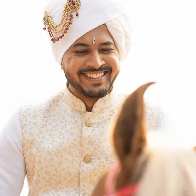 A groom's smile on his wedding day is priceless. Here, I provided grooming that looks completely natural in the bright daylight, along with styling for his traditional white Pheta.