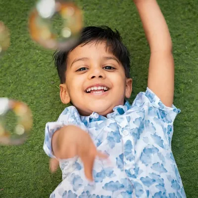 Pure happiness. Capturing a child's joy while playing with bubbles during an outdoor session on the grass.