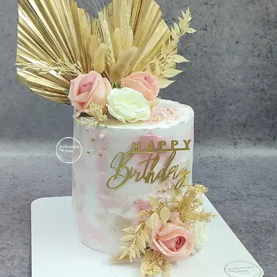 A beautiful rustic floral cake. This design combines a pink marble effect with dried palm leaves, wheat stalks, and delicate pink and white roses for a chic, boho look.