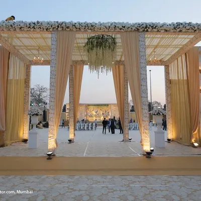 We build structures that impress. This main gate, constructed with a large truss, elegant drapery, and leather paneling, creates a grand and sophisticated entrance for a large-scale wedding.