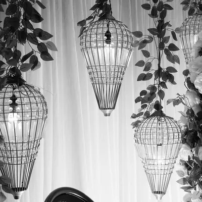 A black and white shot highlighting the beautiful form of our birdcage-style hanging lanterns. These details add a layer of sophistication and visual interest to our stage designs.