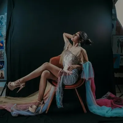 A stylized behind-the-scenes shot from a fashion shoot. This image shows the studio environment with lighting equipment visible, giving a sense of the creative space where we build the final look.