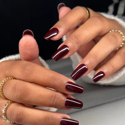 A timeless and sophisticated look. These long, coffin-shaped nails are painted in a deep, glossy burgundy for a look that is bold and elegant.