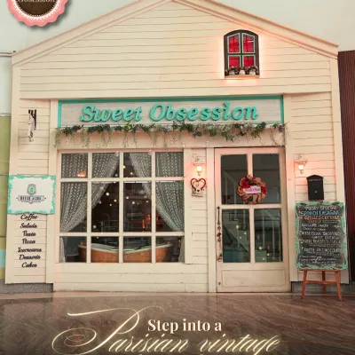 The charming, dollhouse-like facade of Sweet Obsession is your first glimpse into the magical world I've built inside. It’s the perfect spot for a photo before you even step through the door.