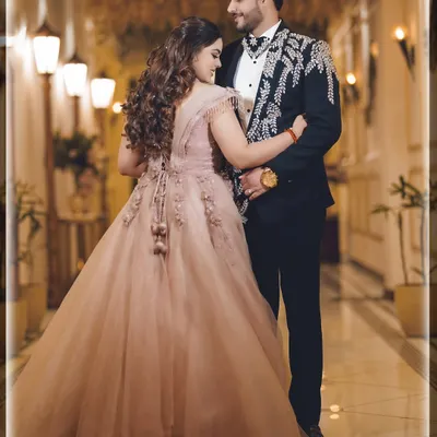 A fairytale moment from an engagement night. The beautiful gown, the elegant ballroom, and the loving gaze all come together to create a picture of pure romance.