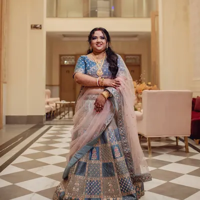 A full-length view of this bride's stunning reception look. Her blue and silver lehenga was complemented by a dramatic smokey eye and a soft pink lip.