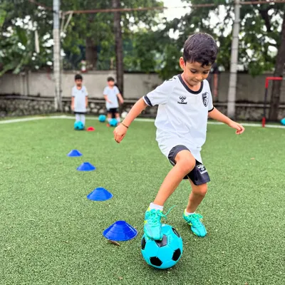 A young player navigates a cone drill, a fundamental exercise we use to develop precise dribbling and close ball control from an early age.