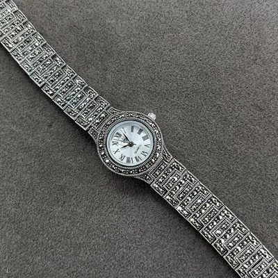 Time is money, but we are just here for the silver bling. A detailed shot of our pure silver watch with a marcasite-studded strap and a classic Roman numeral dial.