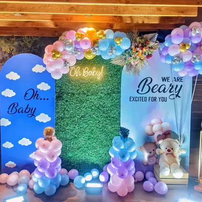 A beautiful 'Oh Baby' shower setup with a 'Beary Excited' theme. I used arched backdrops, a green hedge wall, a neon sign, and pastel balloon arrangements to create this modern and sweet look.